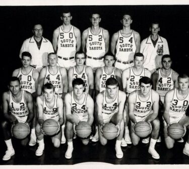 Roger Schaffer poses with the USD Men's Basketball Team during the 1963-1964 season.