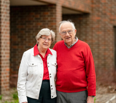 Truman and Beverly Schwartz stand together on USD's campus.